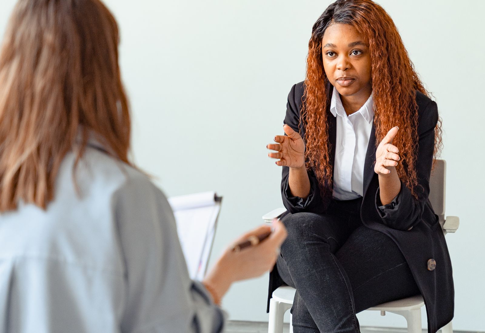 Two people in conversation in a consulting room (placeholder photography)